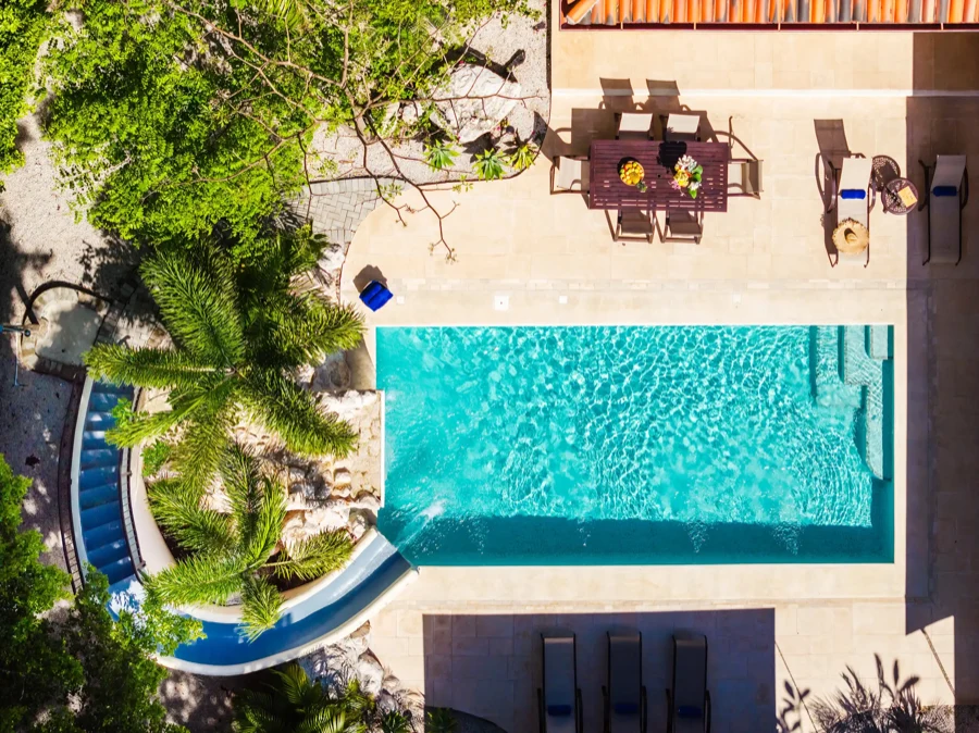 Aerial view of the Casa Bonita Beach pool and waterslide surrounded by palms