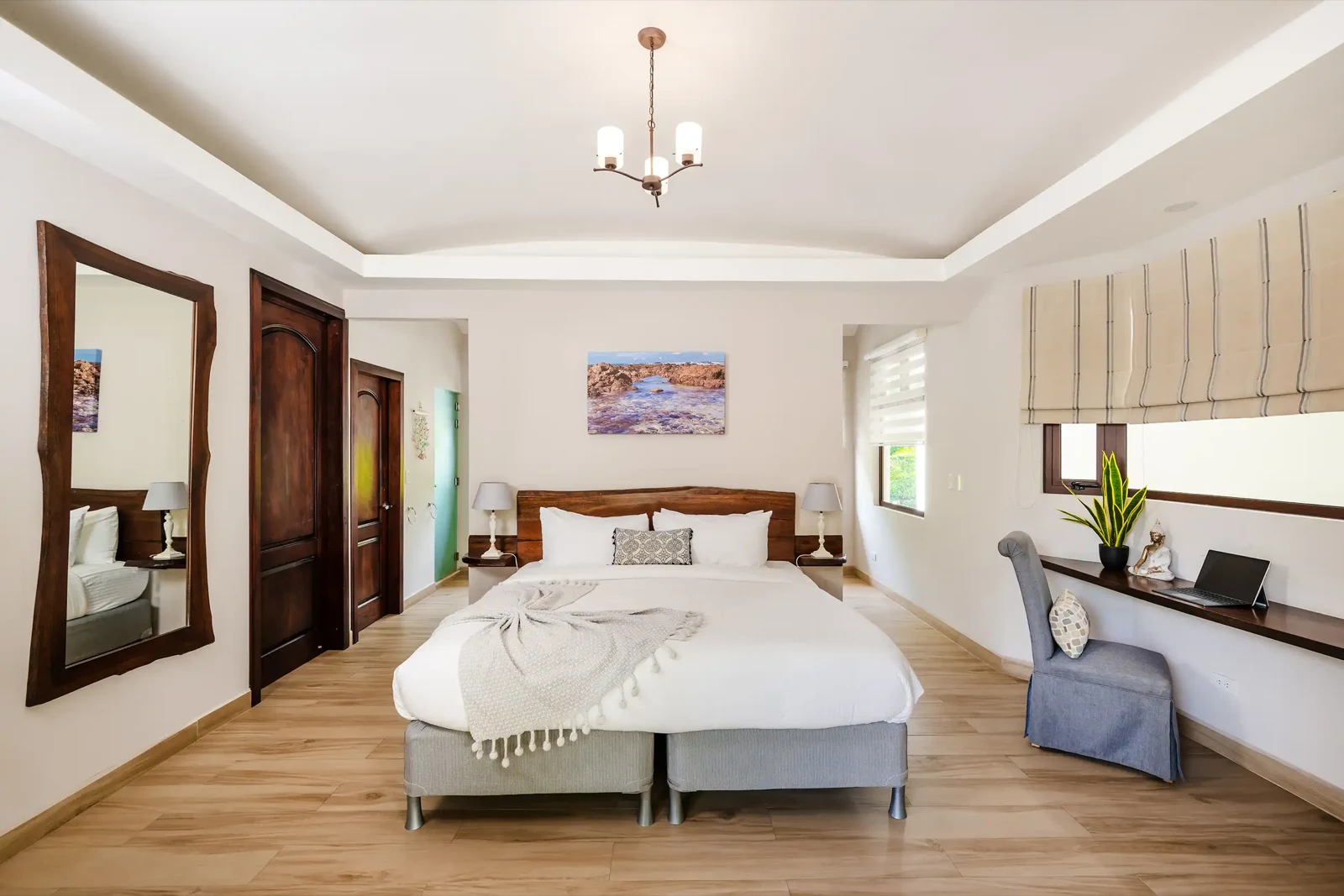 One of the six bedrooms, with a made bed and the door to its own bathroom