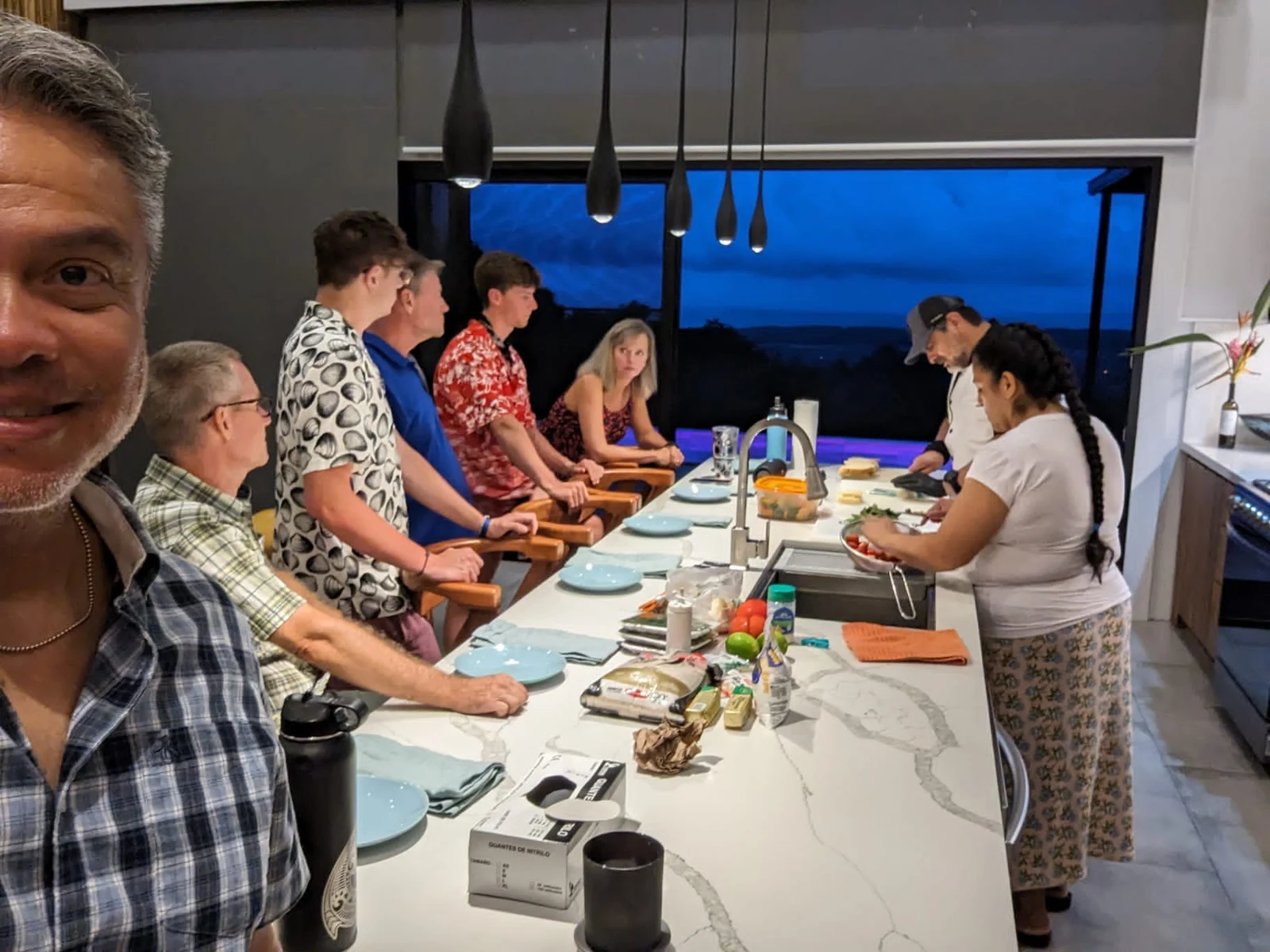Chef Eddie and his team serving a private dinner at a villa with guests seated at the counter