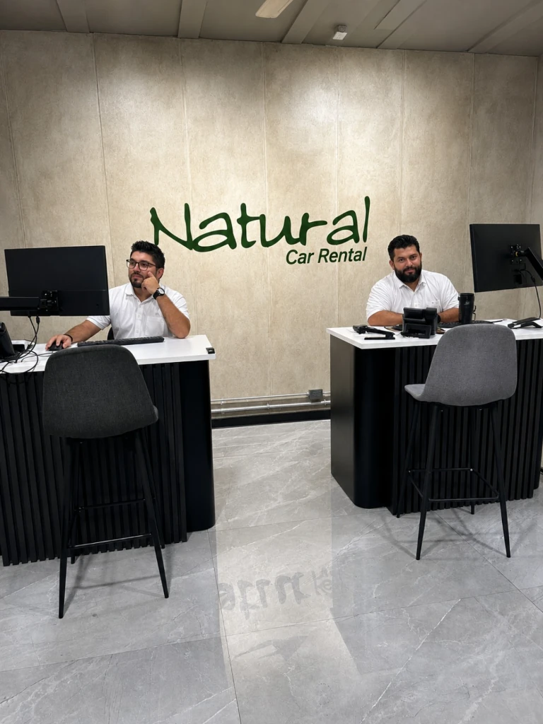Two staff members at their desks in the reception area