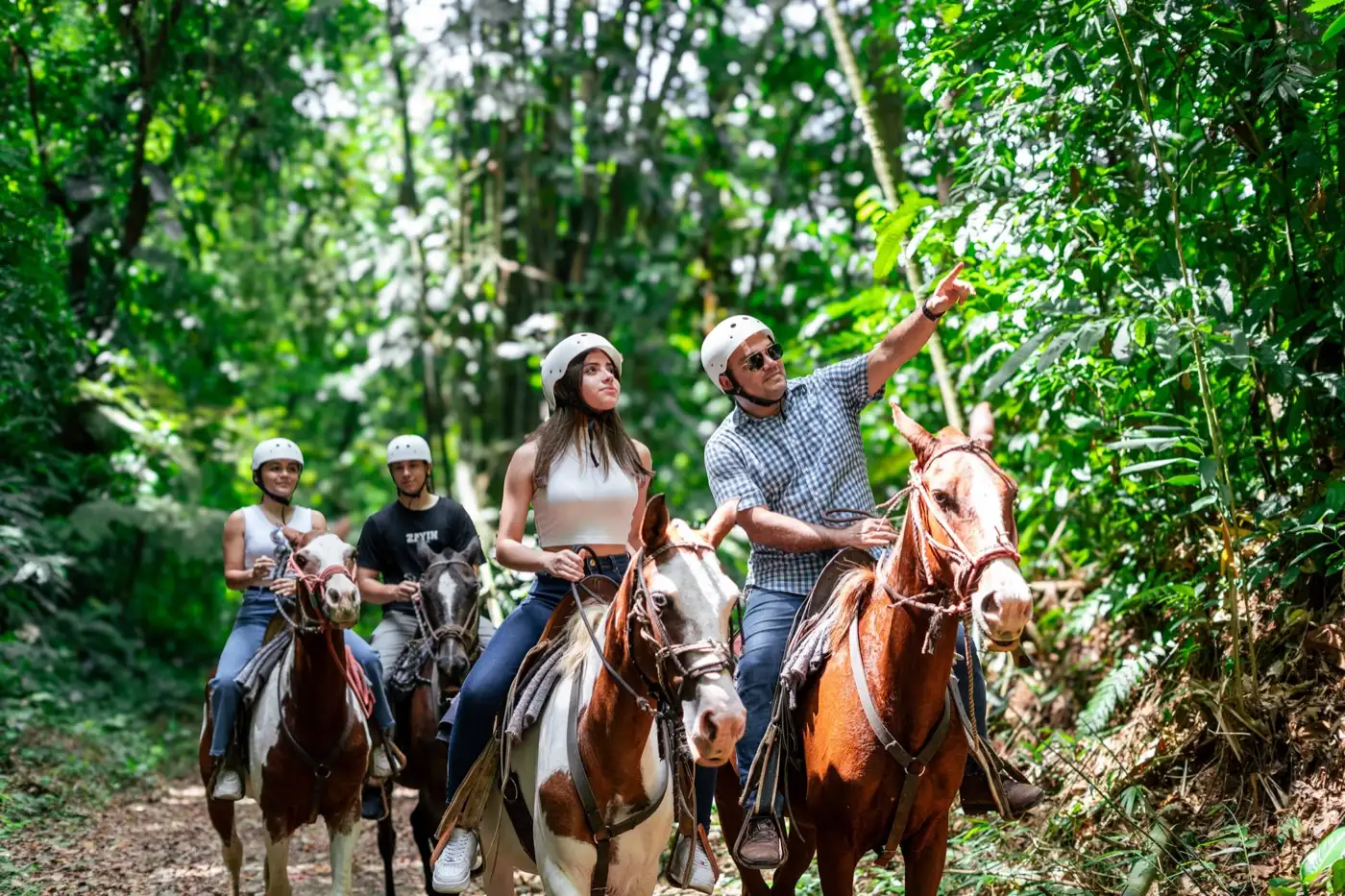 A Tucanes Tours guide leading guests on a horseback ride through the forest