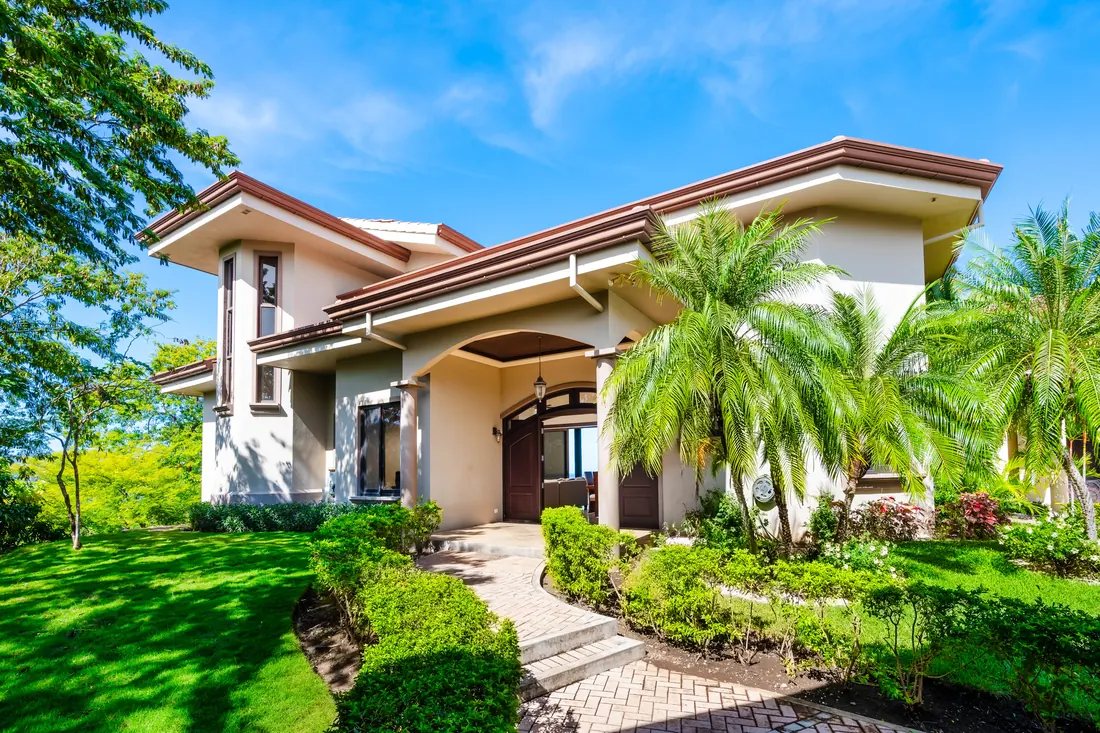 Front entrance framed by palms and planted garden